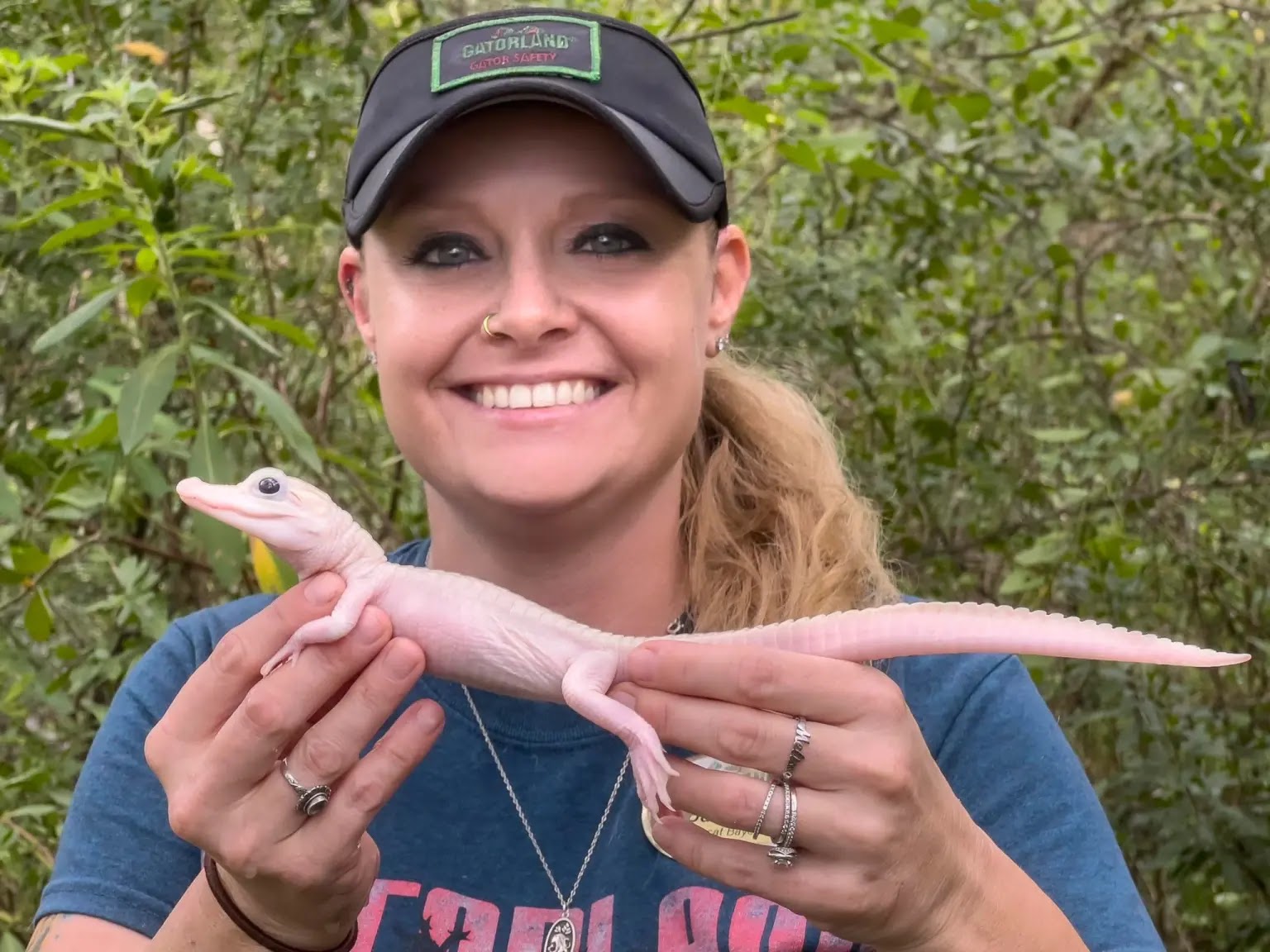 a woman holding a white gator