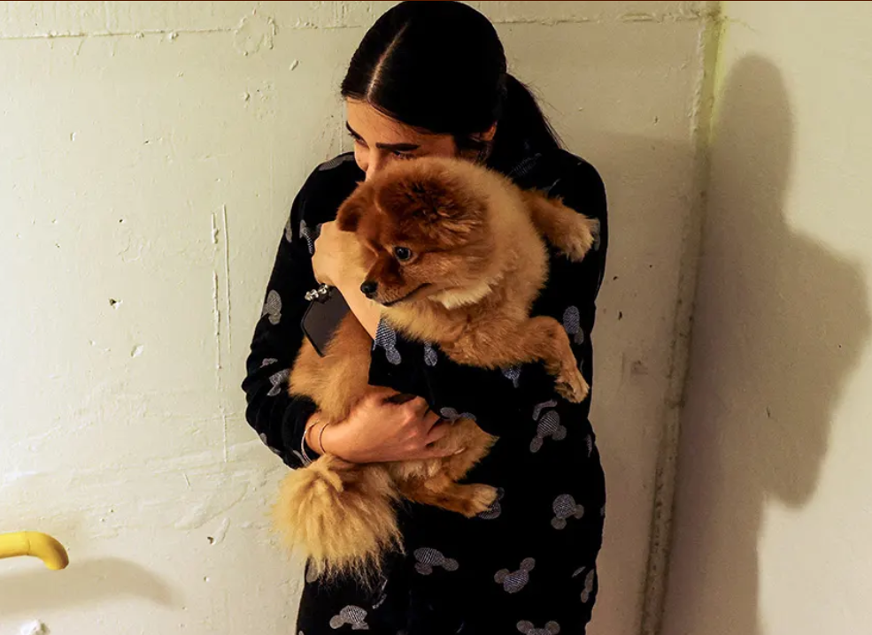 A woman carrying her dog