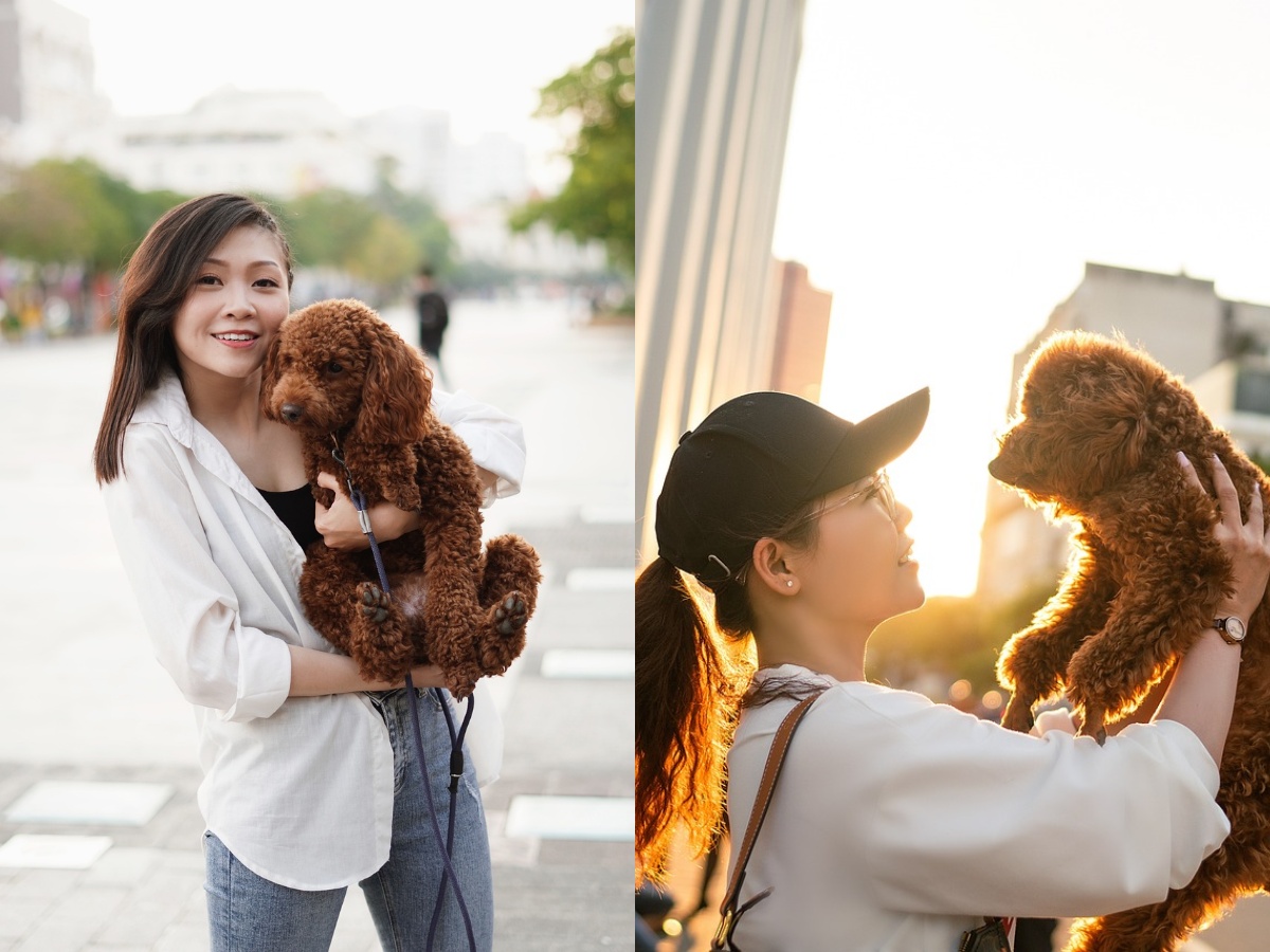 A woman carrying her doodle dog
